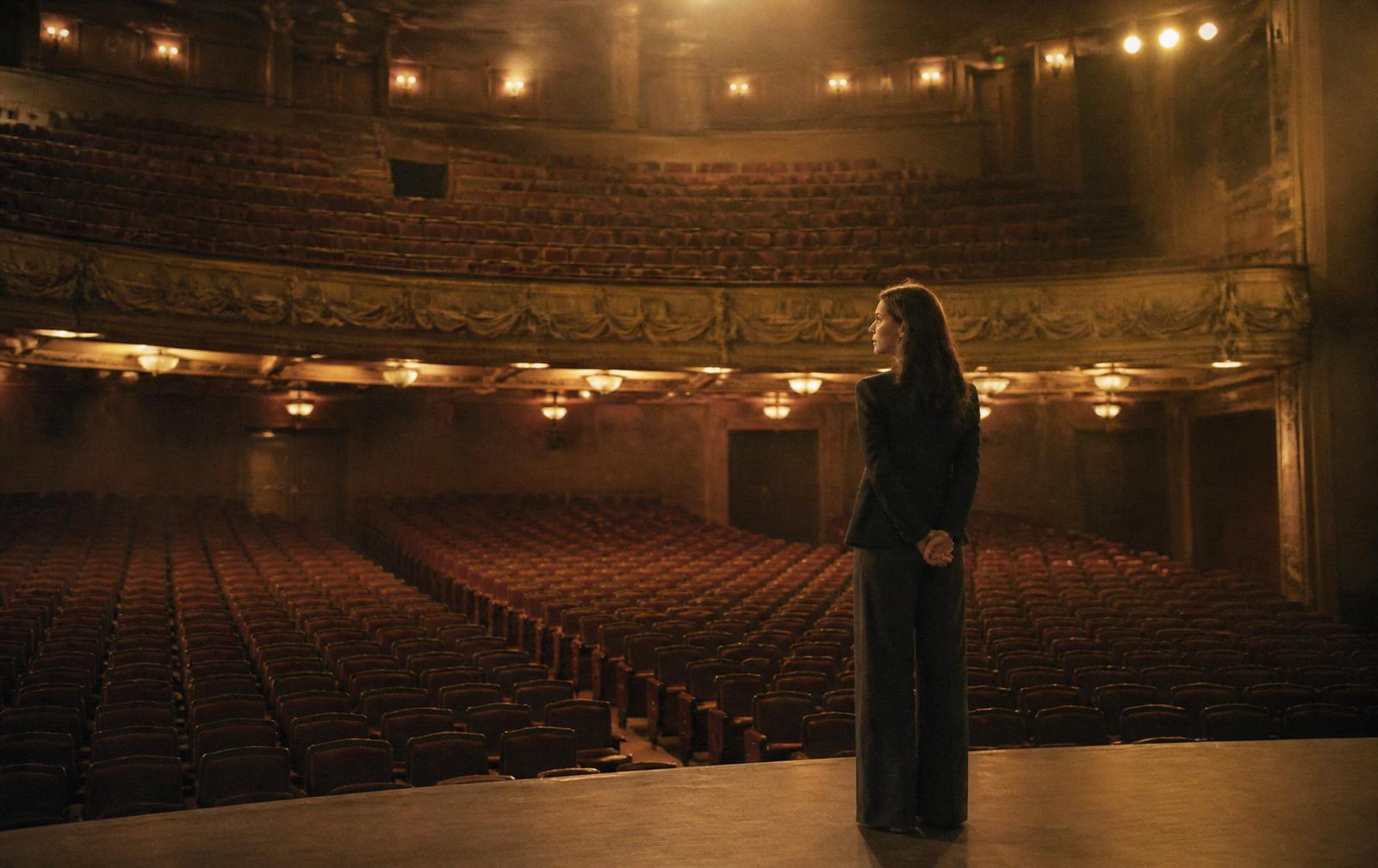 A woman standing at the edge of a beautiful empty auditorium before an event